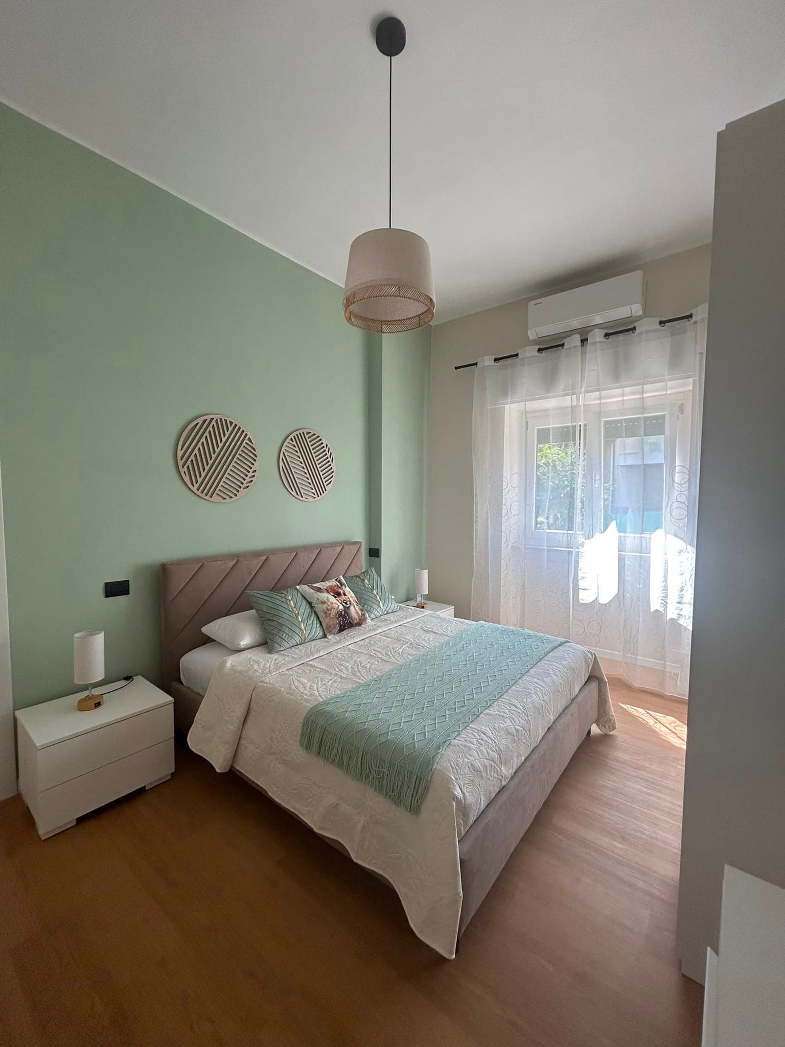 The bedroom with upholstered headboard and natural light