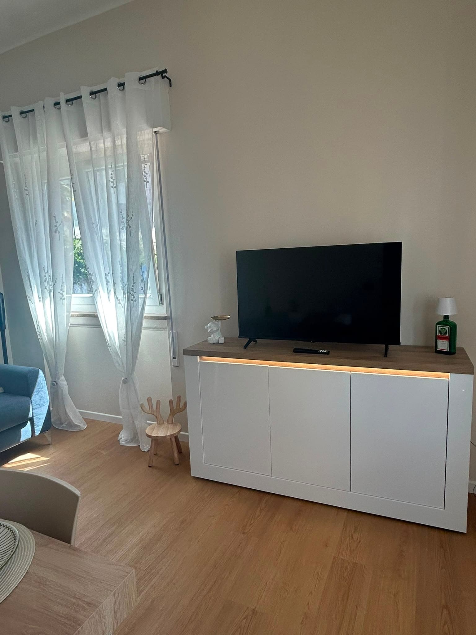 The living room with a flat-screen TV and white sideboard